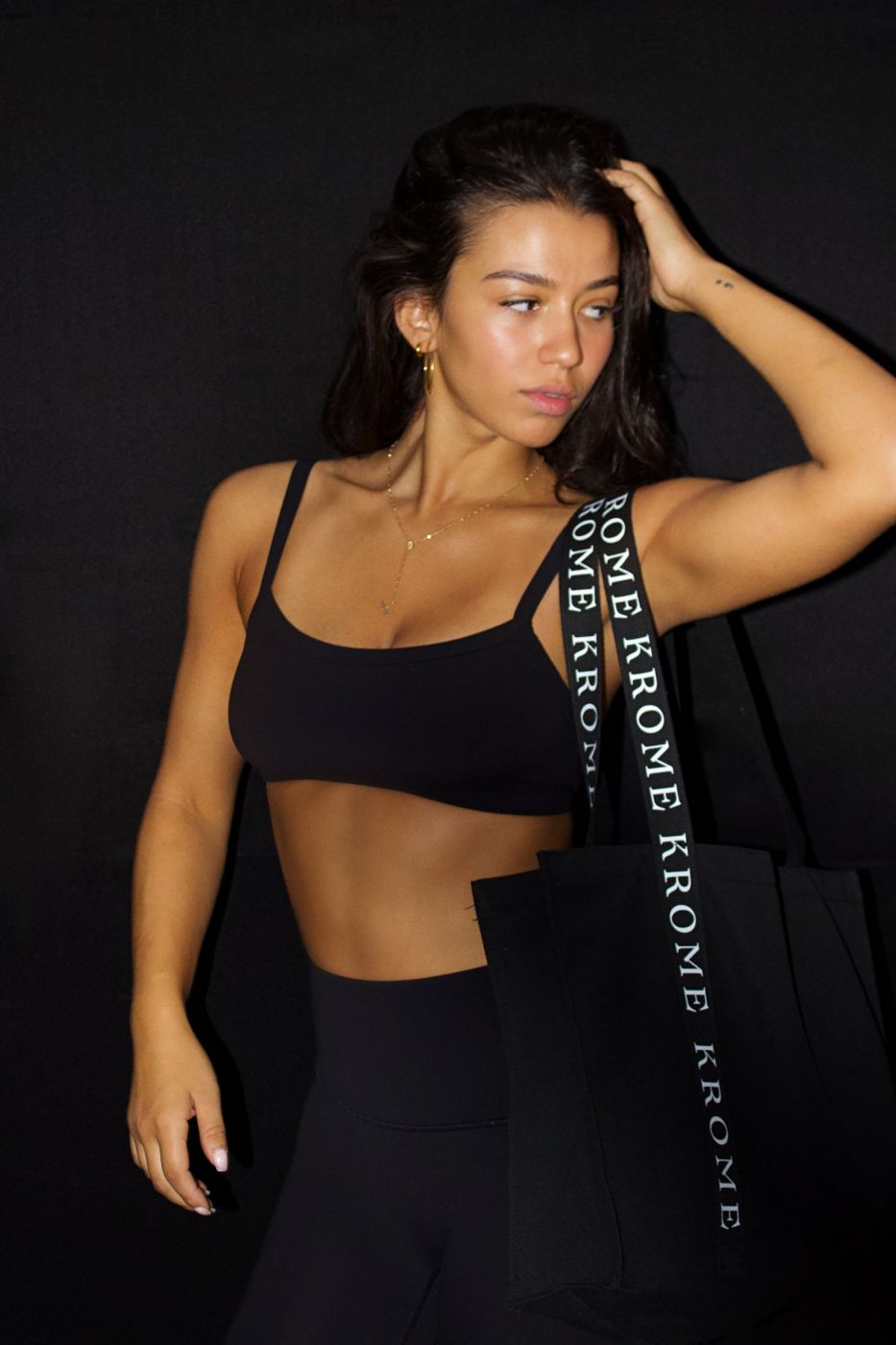 Woman in black activewear carrying a Krome tote bag
